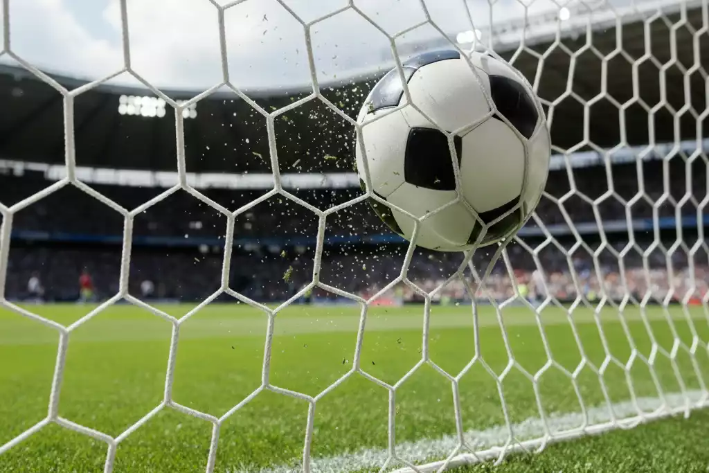 Voetbal in het net van het doel met scorebord op de achtergrond